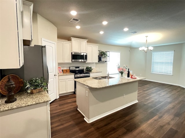 kitchen with appliances with stainless steel finishes, white cabinetry, a kitchen island with sink, and sink