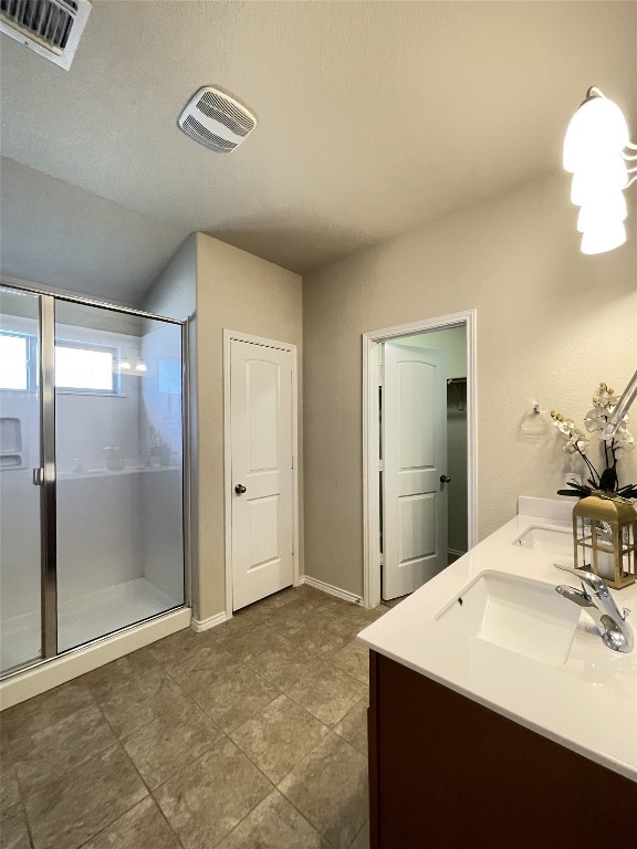 bathroom with vanity, a shower with shower door, and lofted ceiling