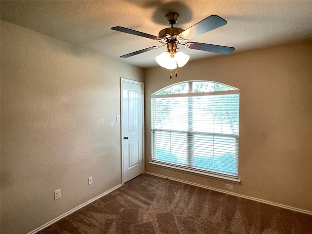 carpeted spare room featuring ceiling fan and a healthy amount of sunlight