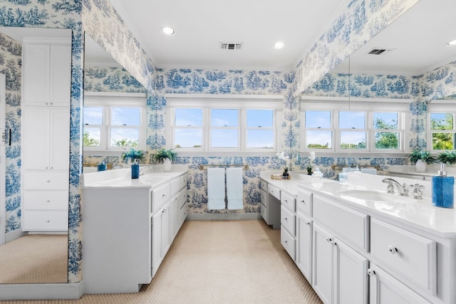 bathroom with vanity, ornamental molding, and a healthy amount of sunlight