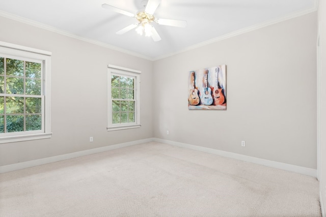 carpeted spare room with ornamental molding, ceiling fan, and a healthy amount of sunlight