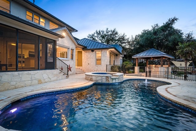 view of swimming pool featuring pool water feature, an in ground hot tub, a patio area, and a gazebo