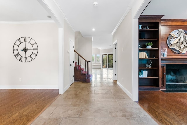 entryway featuring light hardwood / wood-style flooring, a fireplace, and crown molding