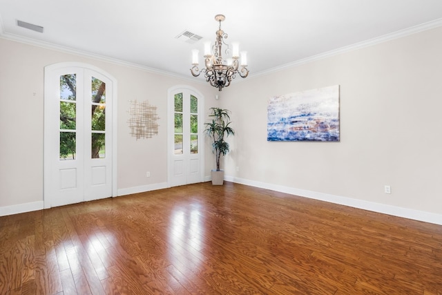 foyer with wood-type flooring, crown molding, and a chandelier