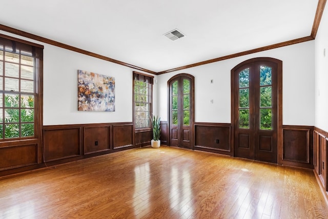 foyer featuring light hardwood / wood-style flooring, ornamental molding, and a healthy amount of sunlight