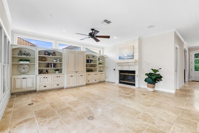 unfurnished living room with ornamental molding, a premium fireplace, and ceiling fan