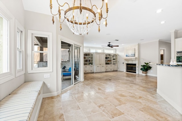 unfurnished living room with ceiling fan with notable chandelier, a premium fireplace, and ornamental molding