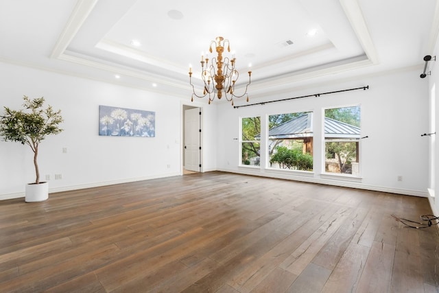 interior space with a notable chandelier, a tray ceiling, crown molding, and dark hardwood / wood-style flooring