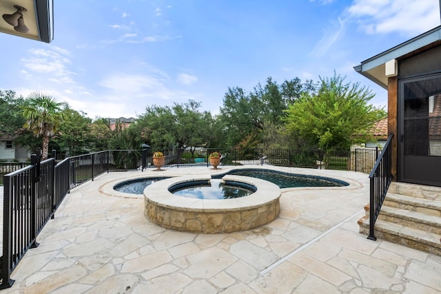 view of swimming pool featuring a patio and an in ground hot tub