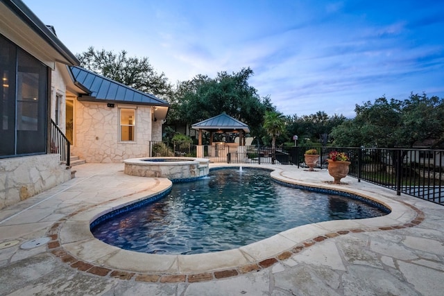 view of swimming pool with a gazebo, an in ground hot tub, pool water feature, and a patio area