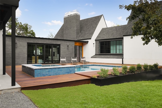 back of house featuring a wooden deck, an in ground hot tub, and a yard