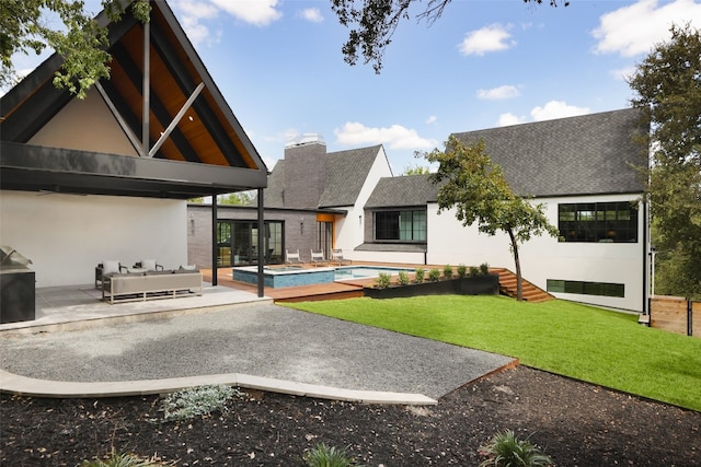 rear view of property with a lawn and a patio