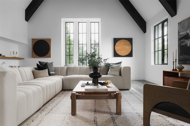 living room with beamed ceiling, light hardwood / wood-style floors, and high vaulted ceiling