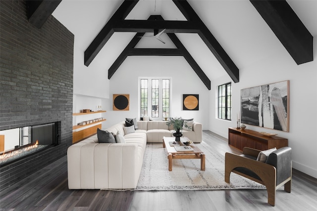 living room with high vaulted ceiling, a wealth of natural light, hardwood / wood-style flooring, and a fireplace