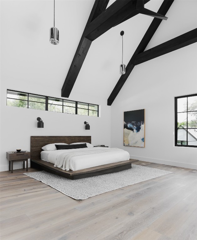 bedroom with beam ceiling, multiple windows, light hardwood / wood-style floors, and high vaulted ceiling