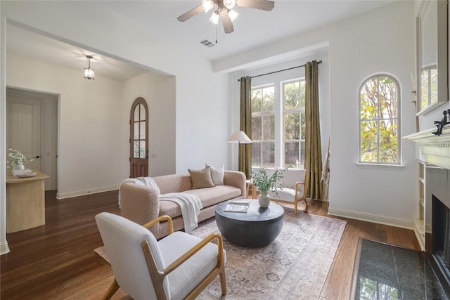 living room featuring ceiling fan and dark wood-type flooring