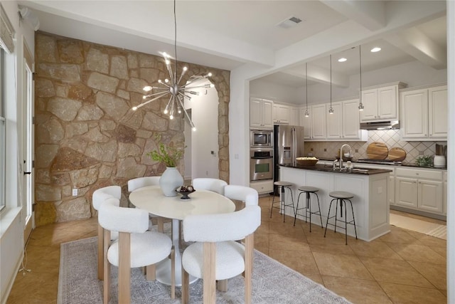 dining area with sink, beamed ceiling, light tile patterned floors, and a notable chandelier