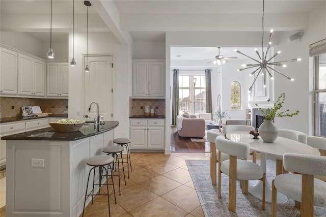 kitchen with white cabinets, backsplash, hanging light fixtures, and beamed ceiling