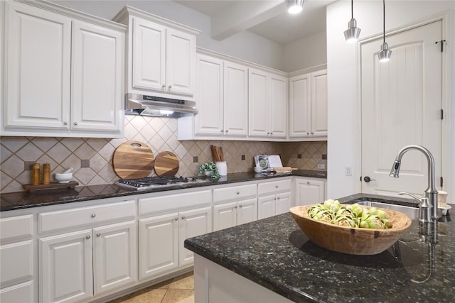 kitchen with white cabinets, dark stone counters, decorative light fixtures, and stainless steel gas cooktop