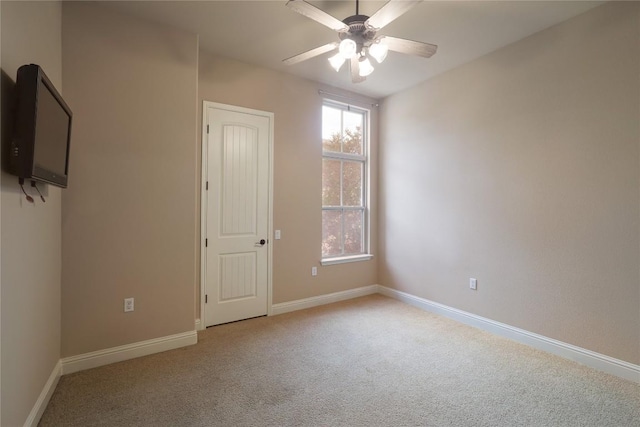 carpeted spare room featuring ceiling fan