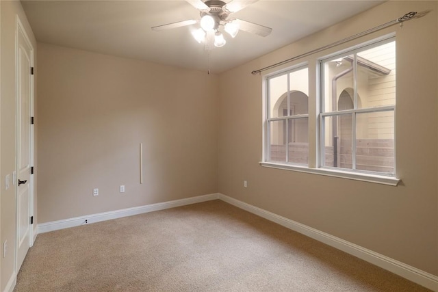 carpeted spare room featuring ceiling fan