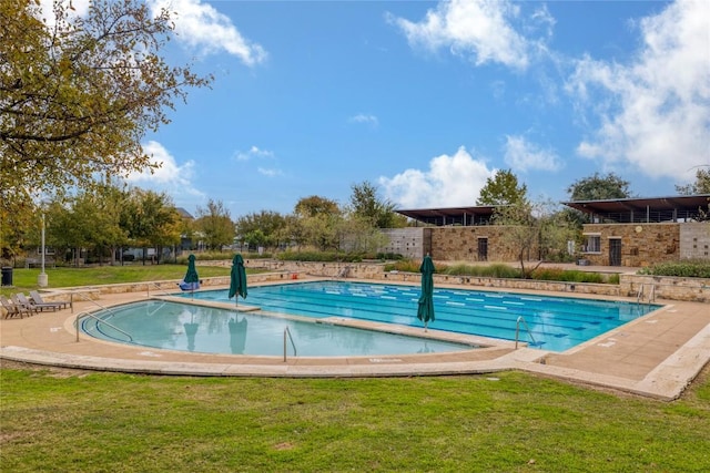 view of pool with a yard