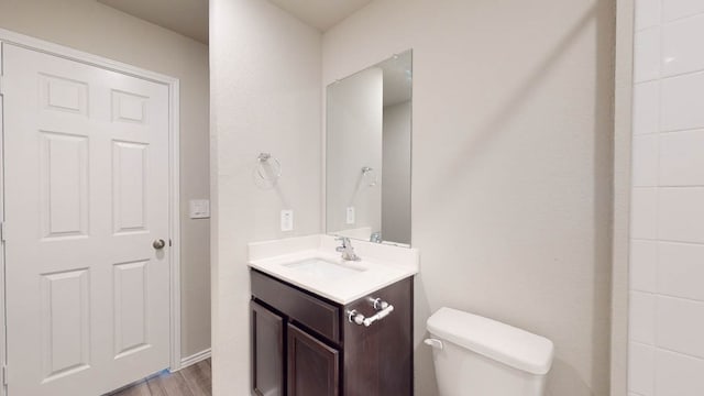 bathroom featuring vanity, toilet, and hardwood / wood-style flooring