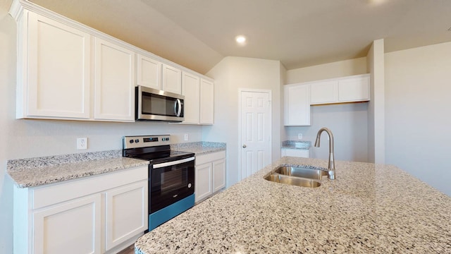 kitchen with light stone countertops, sink, stainless steel appliances, and white cabinets