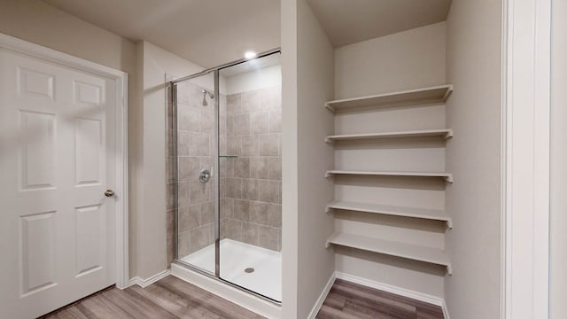 bathroom featuring a shower with door and hardwood / wood-style flooring