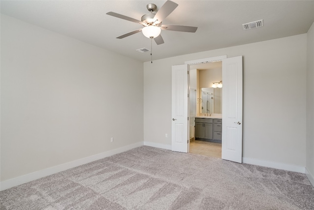 unfurnished bedroom with light carpet, ceiling fan, and ensuite bathroom