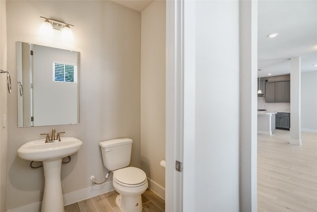 bathroom featuring hardwood / wood-style flooring and toilet