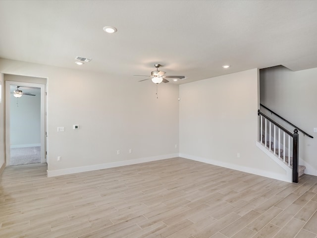 spare room with ceiling fan and light wood-type flooring