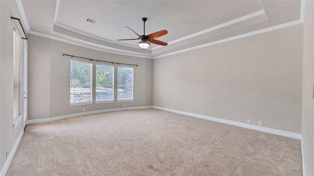 carpeted spare room featuring ceiling fan, crown molding, and a tray ceiling