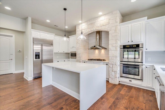 175 Blazing Star Dr, Austin, TX 78737 - kitchen featuring built in appliances, wall chimney range hood, a center island, decorative backsplash, and white cabinetry