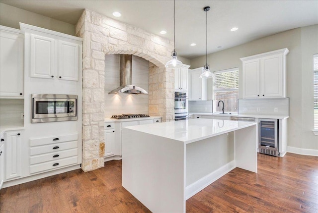 175 Blazing Star Dr, Austin, TX 78737 - kitchen with stainless steel appliances, wall chimney range hood, beverage cooler, decorative backsplash, and recessed lighting
