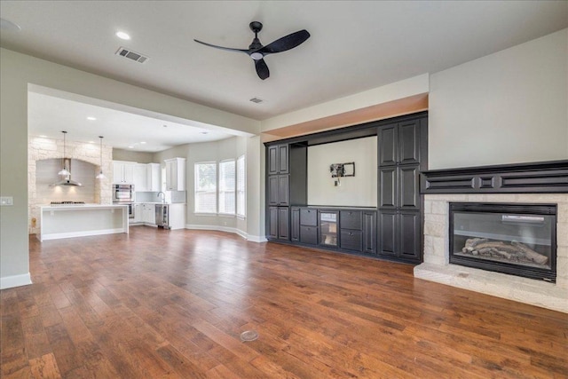 175 Blazing Star Dr, Austin, TX 78737 - unfurnished living room featuring ceiling fan, dark wood-type flooring, a fireplace, beverage cooler, and recessed lighting