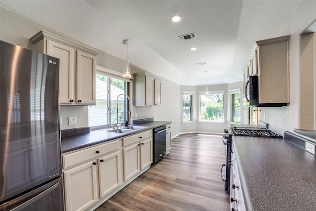 kitchen featuring light hardwood / wood-style floors, sink, appliances with stainless steel finishes, decorative light fixtures, and cream cabinets