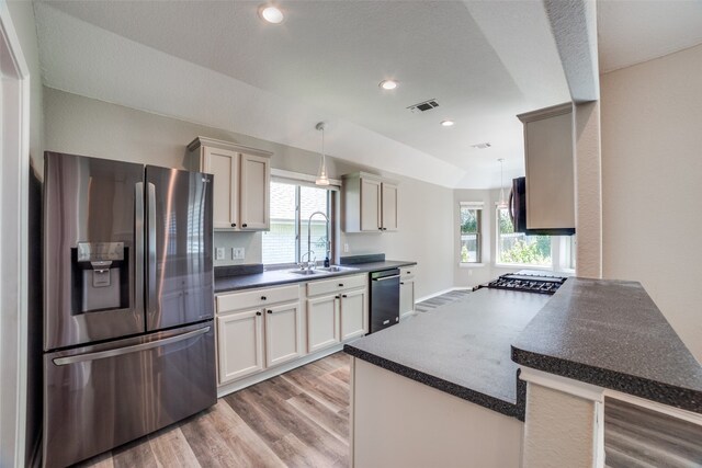 kitchen with appliances with stainless steel finishes, hanging light fixtures, sink, and plenty of natural light