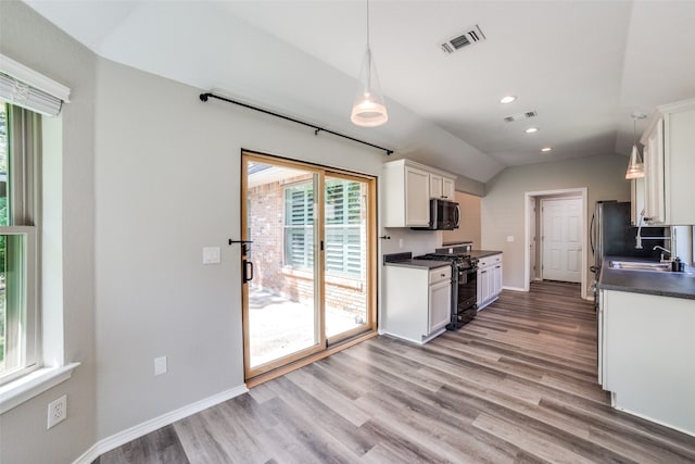 kitchen featuring light hardwood / wood-style flooring, black gas stove, white cabinetry, and hanging light fixtures