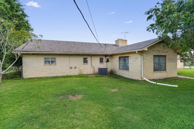 back of house with cooling unit and a yard