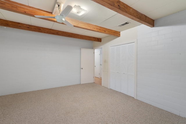 basement featuring ceiling fan, brick wall, and carpet