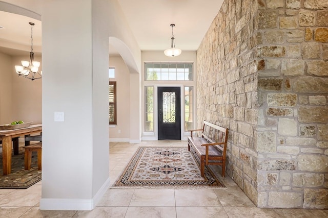 tiled foyer entrance with a chandelier