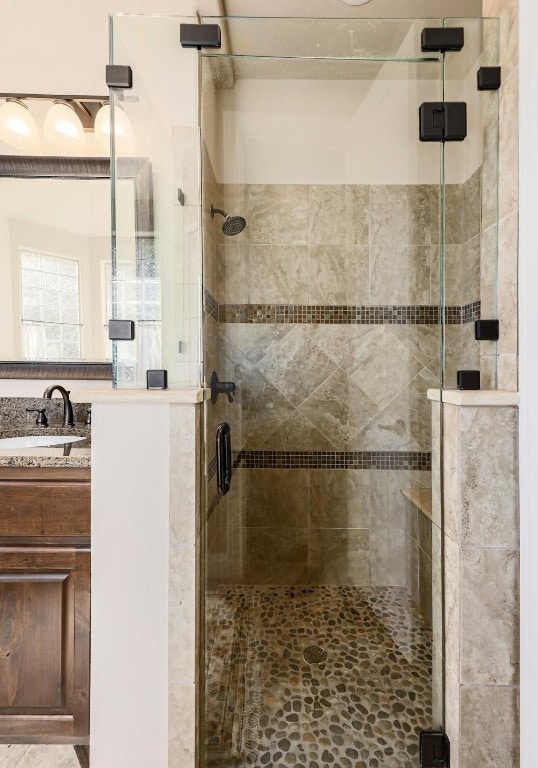 bathroom featuring vanity and a shower with door