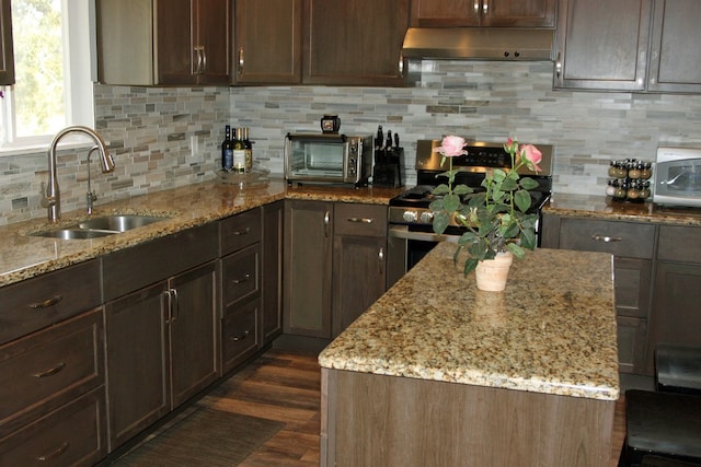 kitchen featuring dark hardwood / wood-style flooring, light stone countertops, stainless steel range, dark brown cabinetry, and sink