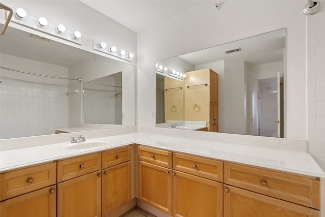 bathroom featuring a tile shower and vanity