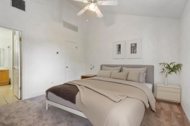 carpeted bedroom with ensuite bathroom, high vaulted ceiling, and ceiling fan