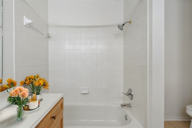 full bathroom featuring tile patterned flooring, toilet, vanity, and tiled shower / bath