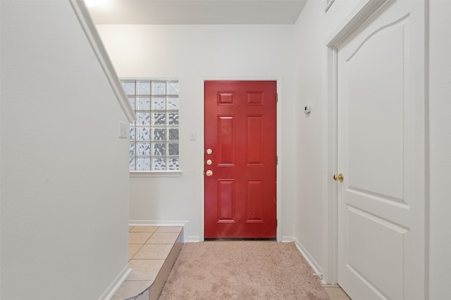 foyer entrance featuring light carpet