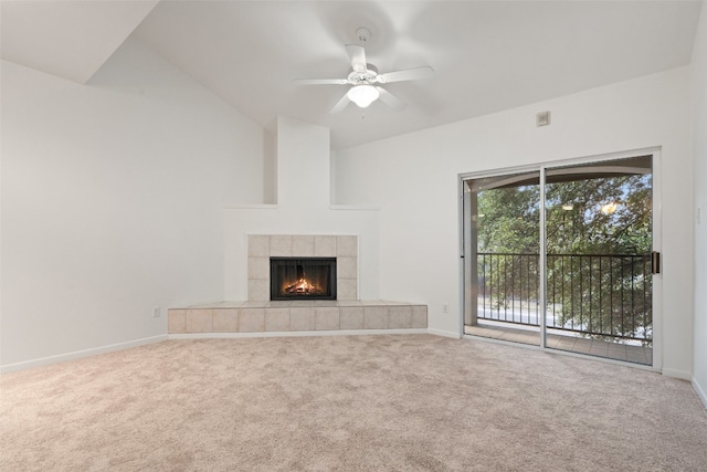 unfurnished living room with a tiled fireplace, ceiling fan, carpet, and vaulted ceiling