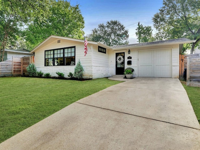 ranch-style home with a garage and a front yard